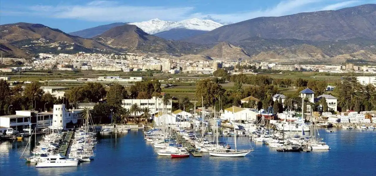 Puerto de Motril con las cumbres nevadas de Sierra Nevada de fondo